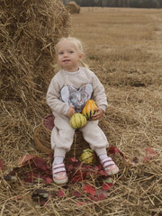 Little girl next to a bale of wheat