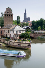 Fototapeta na wymiar Sightseeing boat in Petite France and cathedral from Ponts Couverts, Strasbourg, France