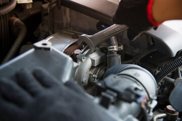Obraz na płótnie Canvas Car service ,fitting a car engine with wrench