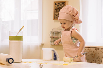 Little girl cooks at home in the kitchen