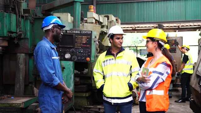 A group of technicians are discussing the operation of machines in large industrial plants.
