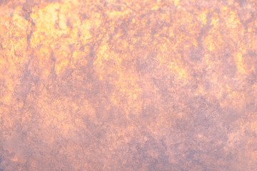 The texture of sea ice with small patterns and bubbles, which is highlighted by the sun. Ice background