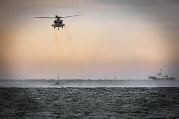 A US Navy MH-60 helicopter with rescue swimmers practices off the coast in Tokyo Bay.