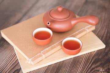 Purple clay pot and two bowls of hot tea and notebook