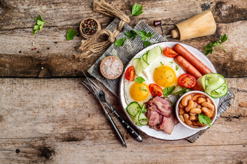 English breakfast with fried egg, sausage, bacon, beans. Food recipe background. space for text. top view