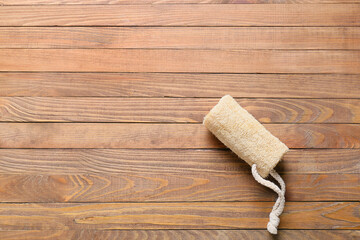 Loofah on wooden background, top view