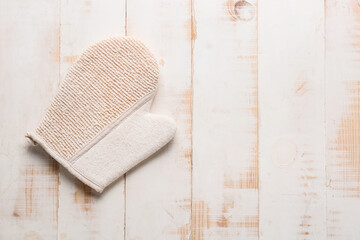 Massage glove on wooden background