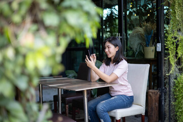 Asian women are working and listening to music on mobile phones.