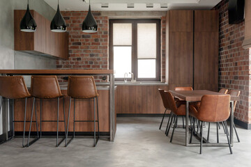 Contemporary interior design of light spacious dinning room including brown wooden furniture with...