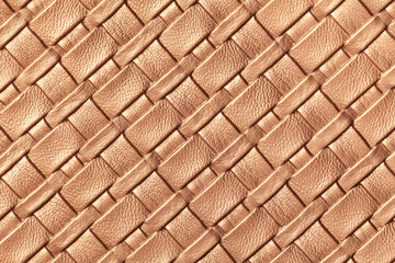 Texture of light brown and beige leather background with wicker pattern, macro