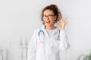 African-American female doctor showing OK in clinic