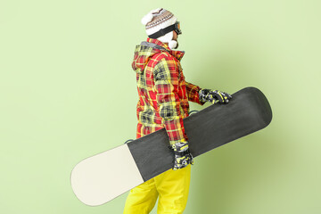 Male snowboarder on color background