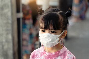 Asian kids girls wear masks on public roads to prevent the spread of COVID 19 or prevent PM2.5.