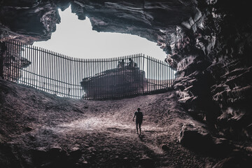 Man walking in dark cave.Outdoor adventure