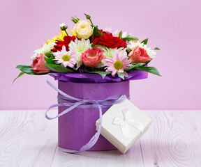 Bouquet of wildflowers and gift box on wooden boards.