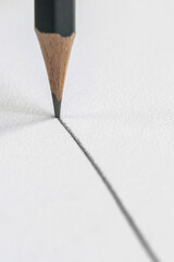 a graphite pencil draws a gray line