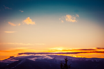 Beautiful dawn in the winter snow-covered mountains and amazingly beautiful clouds