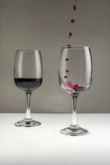 Red wine is poured from a bottle into a glass on a blurred background, close-up.