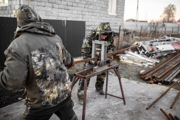 Workers bending metal at a construction site. Technology