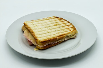 Toast bread sandwich ham with melted tilsiter cheese on white dish, isolated on white background