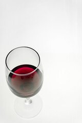 Vertical shot. A glass of red wine on a light background. 