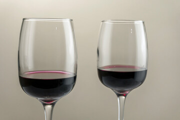 Two glasses of red wine on a blurred homogeneous background. Horizontal photo