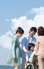 車椅子に座るシニア男性と笑顔の家族