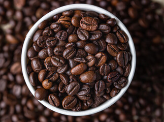 Takeaway coffee recycle cup with roasted coffee beans on coffee beans background. Top view. Close up.