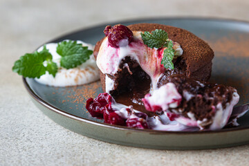Traditional french chocolate cake with liquid filling served with cream, cherry and mint. Chocolate fondant. Chocolate Lava cake.