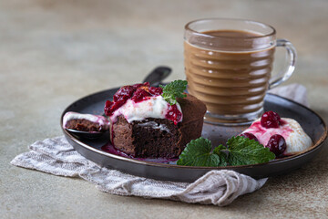 Mini chocolate cake or brownie with cream, cherry and mint on a ceramic plate and cup of coffee. Chocolate fondant. Breakfast or dessert for Woman or Mother Day.
