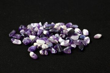 Set of various amethyst natural mineral stones and gemstones on black background