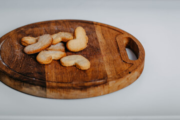 Heart-shaped cookies on round wooden cutting board. Saint Valentine's cookies in shape of heart on white background.