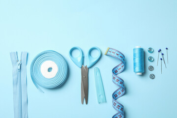 Blue sewing supplies on blue background, top view