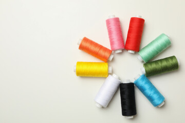 Color sewing threads on white background, top view