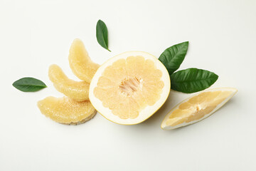 Half of pomelo fruit, slices and leaves on white background