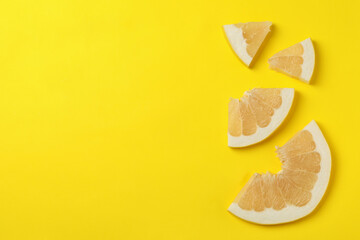 Ripe pomelo fruit slices on yellow background