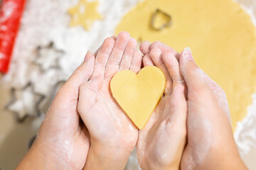 Fototapeta premium A hand holding a piece of food. heart in hands. Happy christmas
