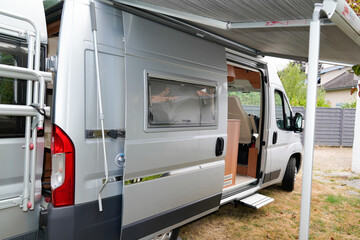 Motorhome gray RV campervan parked open door with awning