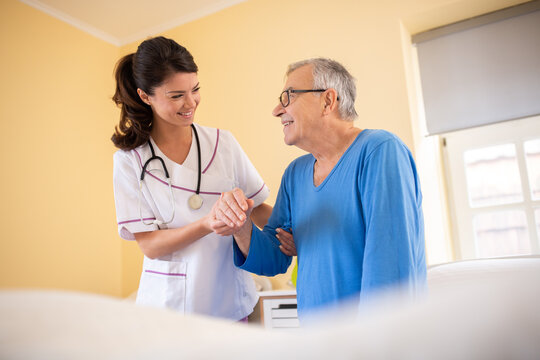 Female doctor in a nursing home facility holding her patient for hand