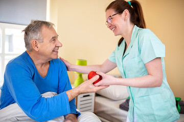Fototapeta premium Elders people home nurse making sure senior man occupant gets healthy food to eat
