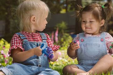 Two little girls sisters paint with finger paints