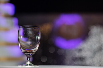 glass of empty wine with purple light background