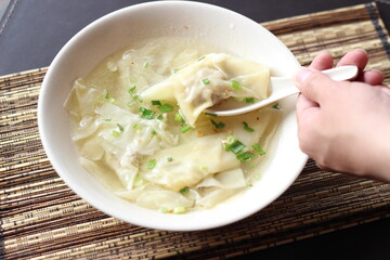 a bowl of dumplings with sweet clear chicken broth