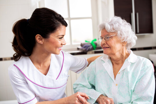 Nurse attending senior woman in a long term care facility, concept of trust