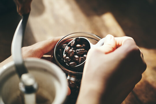 コーヒー豆を計量スプーンで計る女性の手元