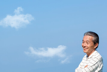 遠くを見つめる笑顔のシニア男性