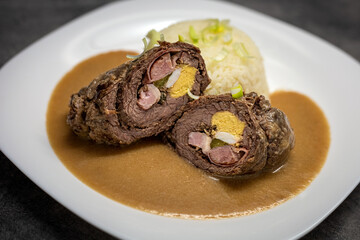 Close up shot of plate with meat roll and rice