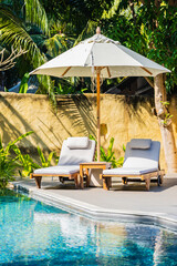 Umbrella and chair around outdoor swimming pool - 405735135