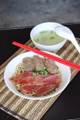 a bowl of noodle with pork meat and soup