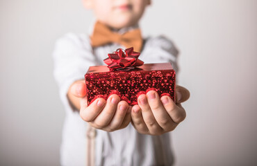 Five year old smiling boy give  a red  gift, Valentines day.